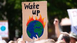 Skilt til klima-demonstration med brændende jordklode og teksten "wake up"