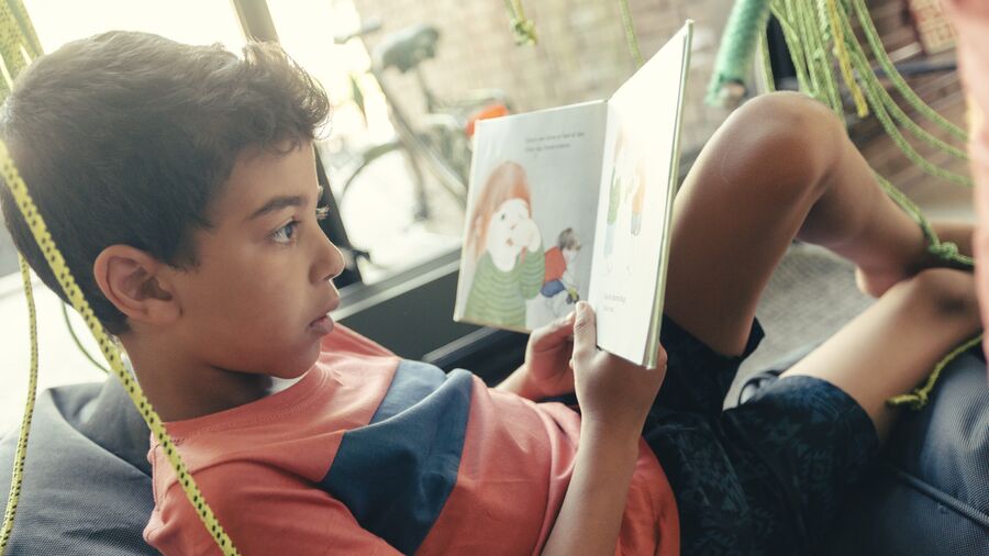 Barn læser i Herlev Biblioteks "skov" af grønne reb