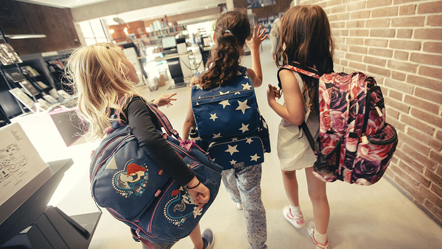 Tre børn med skoletasker på